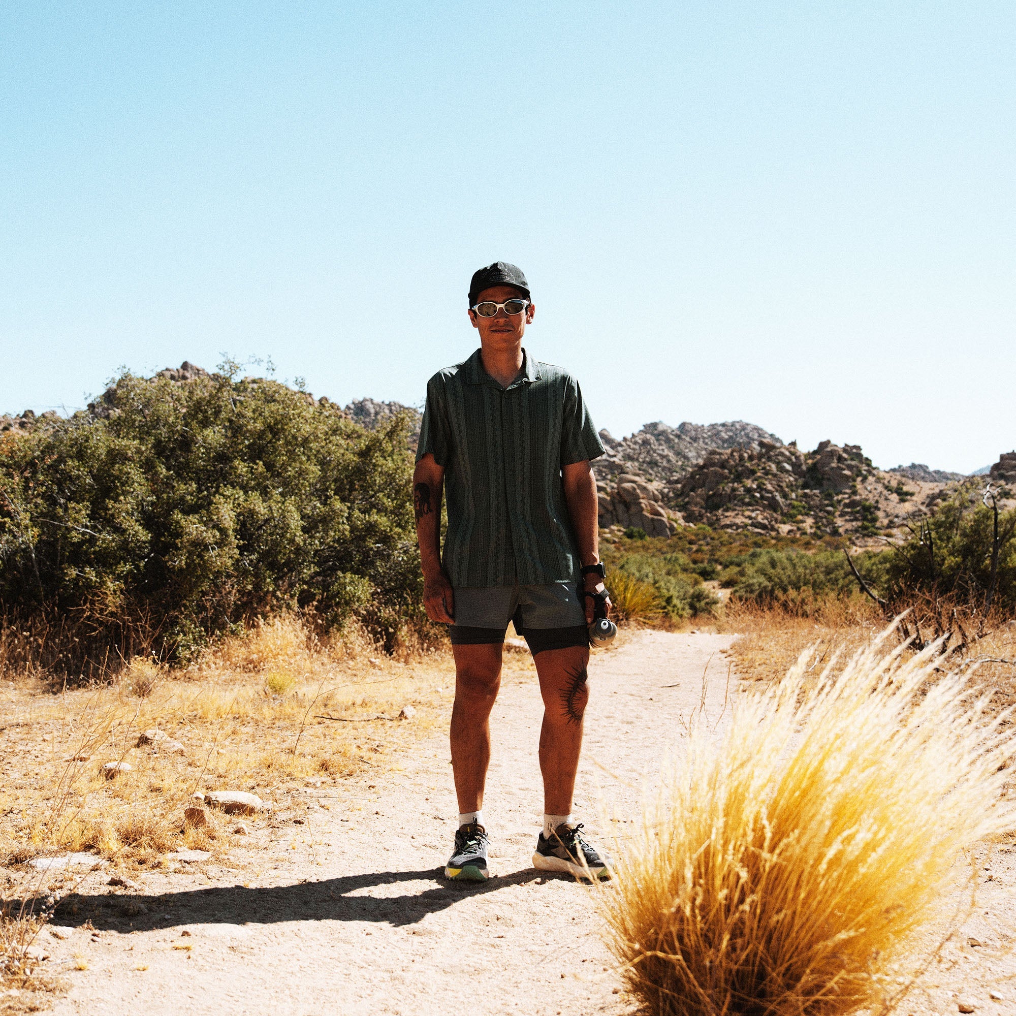 Bless Up Trail Button Up Shirt in Ebony, worn by a runner on a desert trail