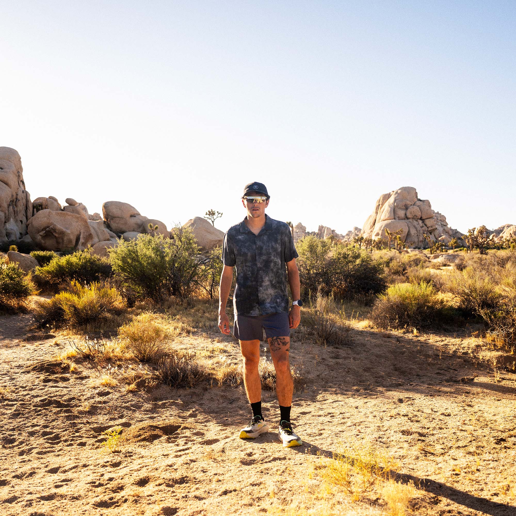 Bless Up Trail Button Up Shirt, worn by a runner on a desert trail among boulders