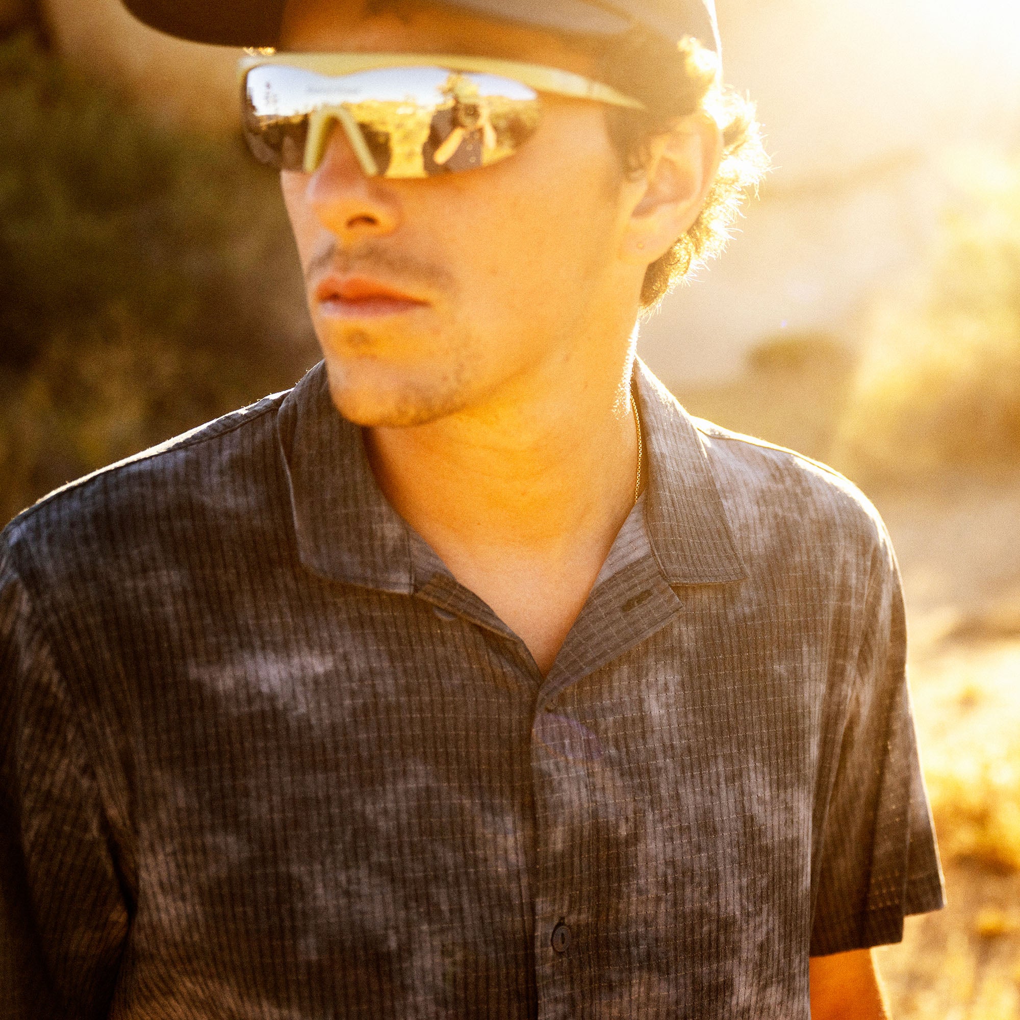 Bless Up Trail Button Up Shirt in Dark Slate, worn by a model outdoors in low sun