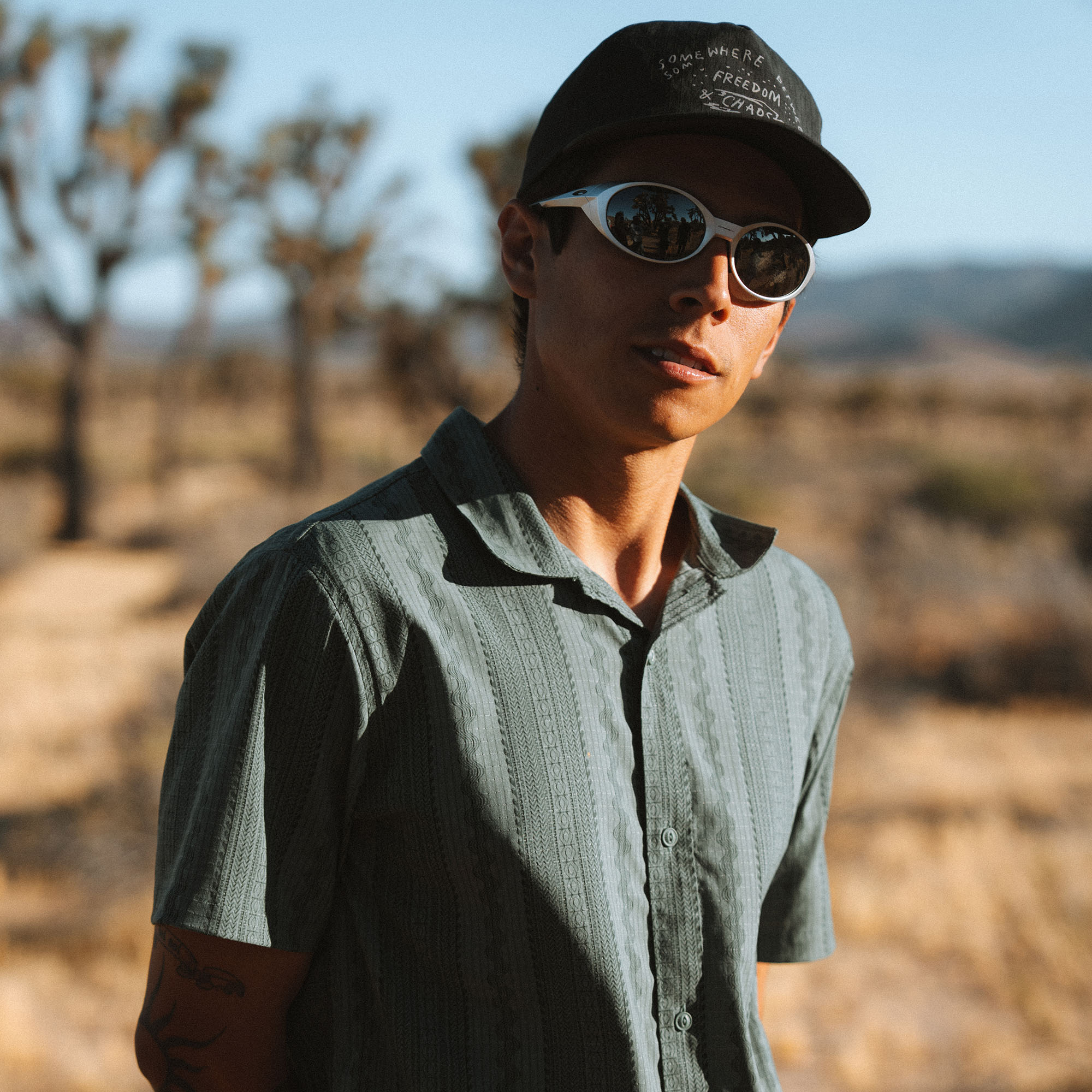 Bless Up Trail Button Up Shirt in Dark Slate, worn by a model in a desert landscape