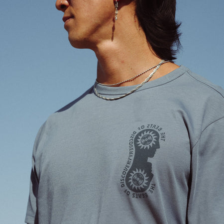 Man wearing Roark Mathis Active Short Sleeve Tee while hiking in a forest, showcasing the shirt's comfortable fit and durability in an outdoor adventure setting.