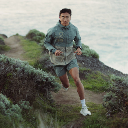 Runner wearing Roark Secondwind 3.0 Jacket on a trail, demonstrating mobility and comfort suited for individual outdoor sports